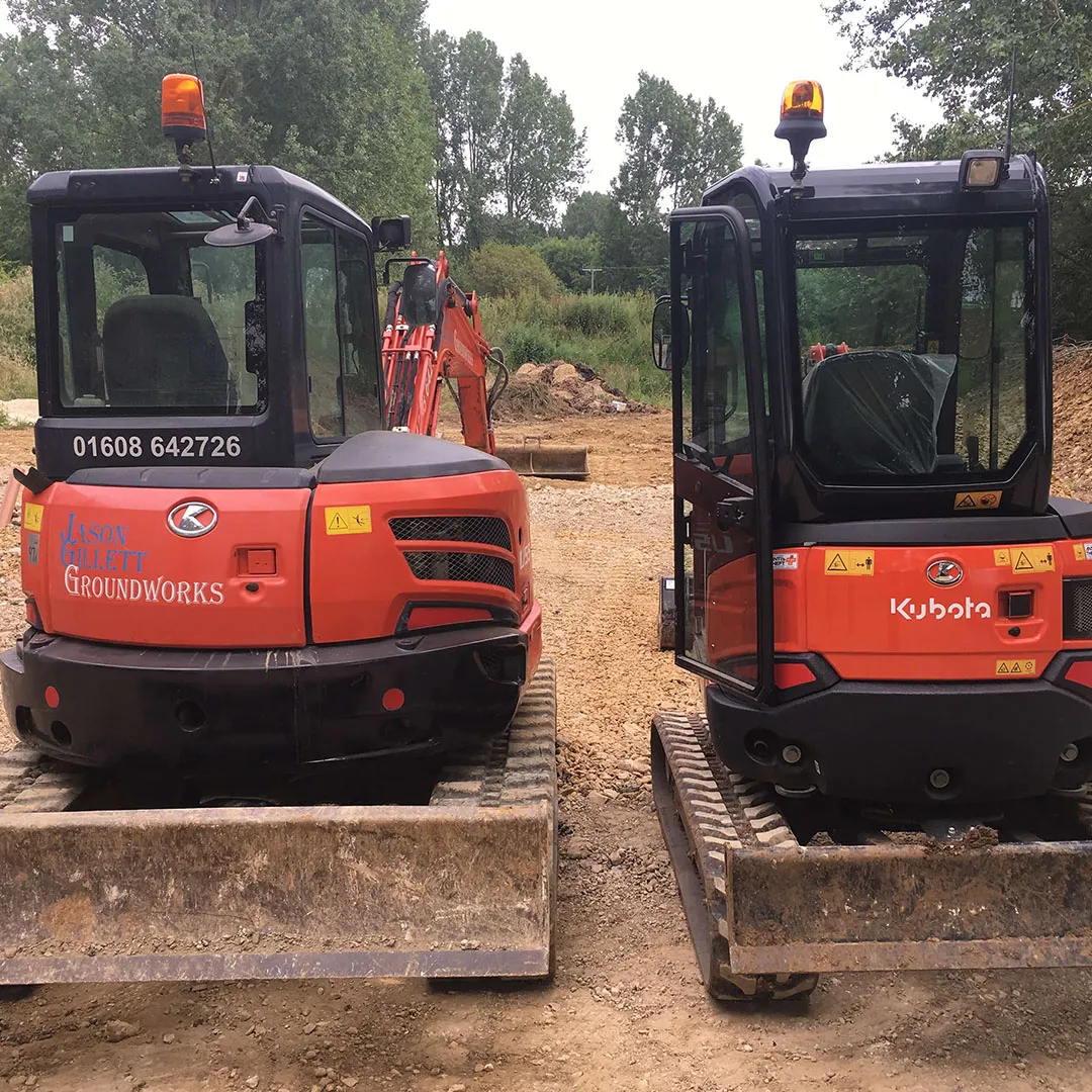 a couple of small machines sitting on top of a dirt field