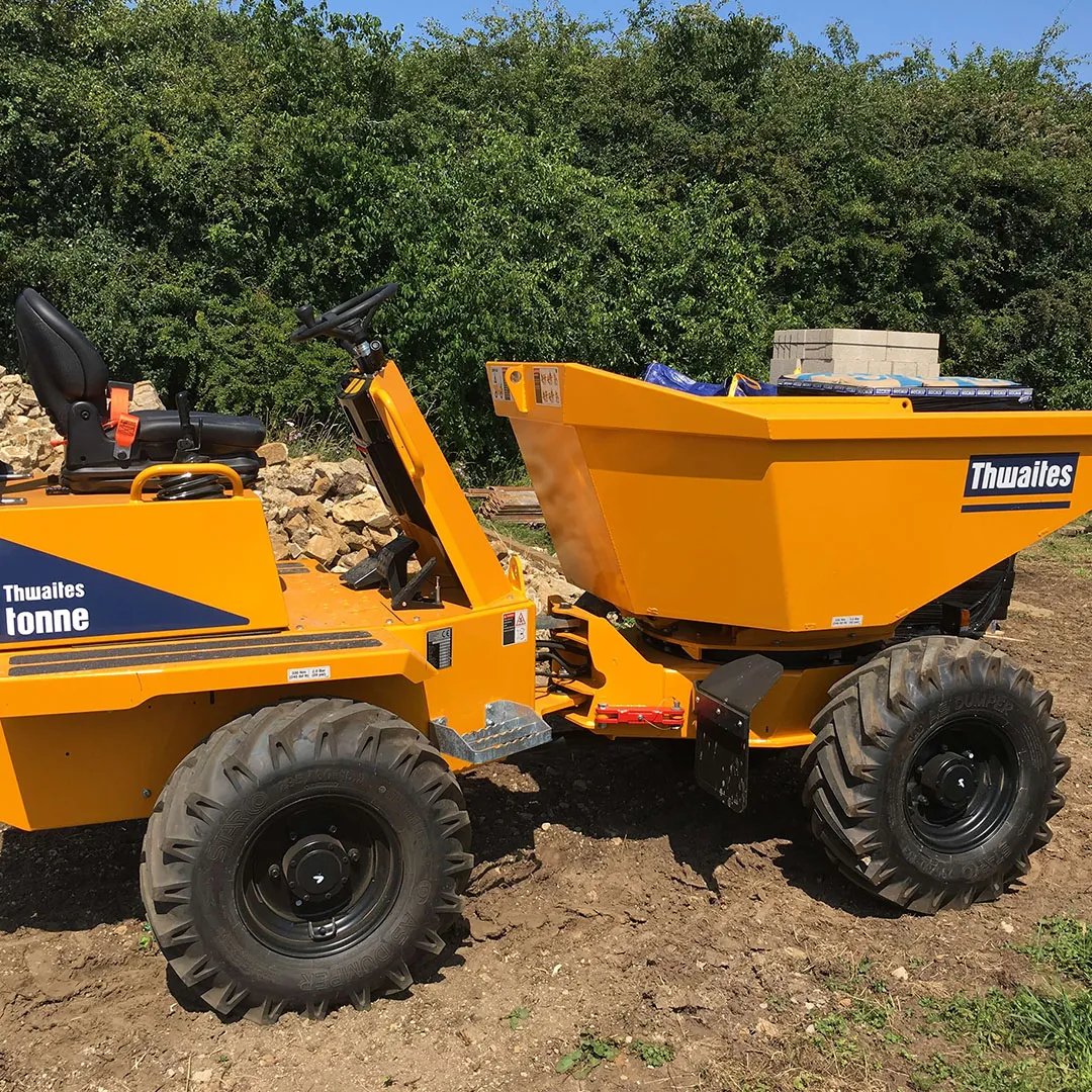 a yellow dump truck sitting on top of a dirt field