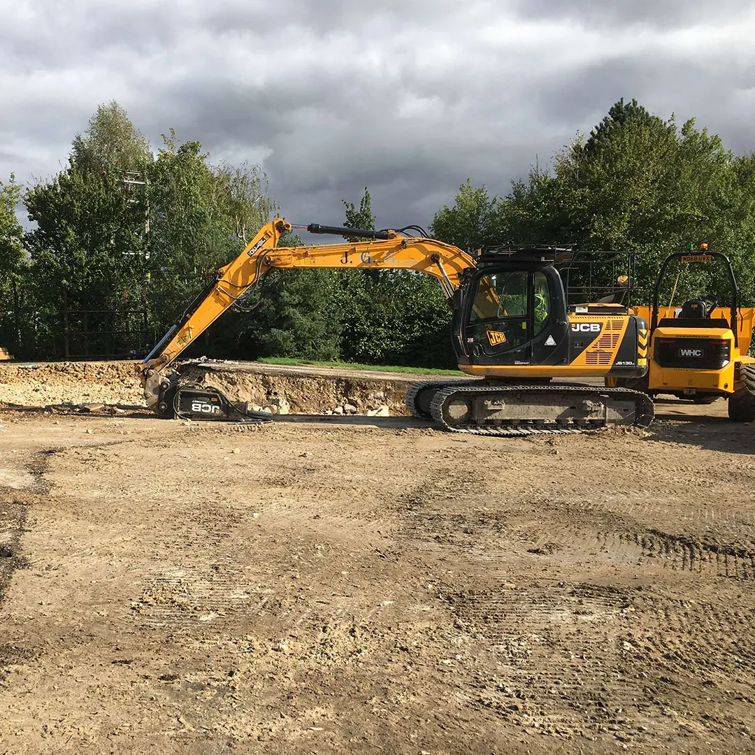a yellow and black bulldozer and some dirt and trees
