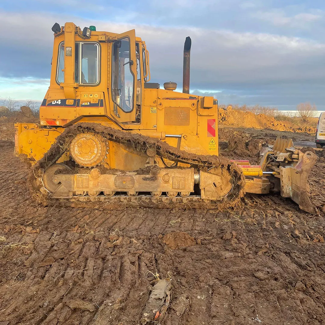 a yellow bulldozer sitting on top of a dirt field