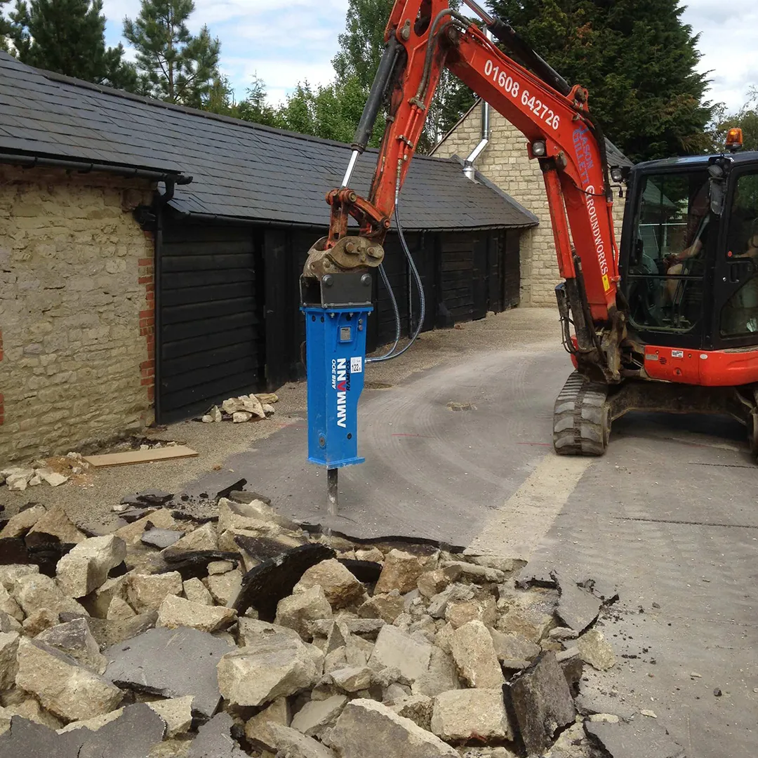 a red excavator digging through a pile of rubble