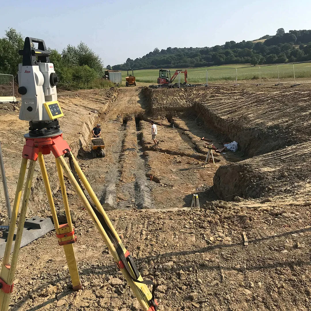 a construction site with a surveying device on a tripod